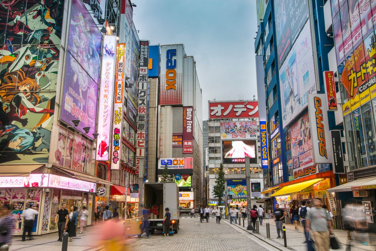 gallery-04 A bustling street in Akihabara, Tokyo filled with bright neon signs and pedestrians.